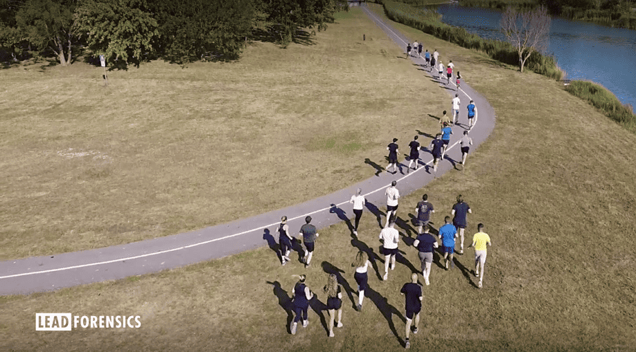 34 people running on and next to a path near a lake